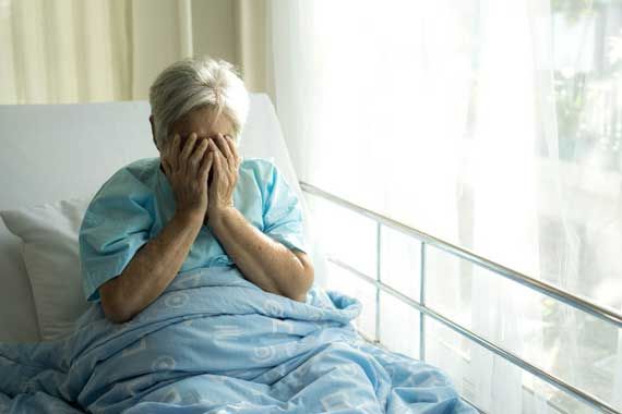 Une personne âgée dans un lit d'hôpital.