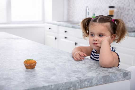 Une fille qui regarde un cupcake.